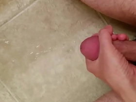 Asian guy masturbates and cums on floor